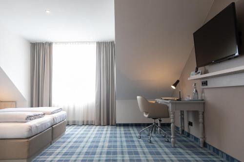 阿希姆哈贝坎普酒店的配有一张床和一张书桌的酒店客房
