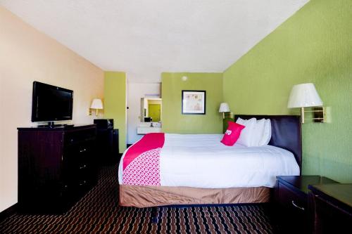 彭萨科拉OYO Hotel Pensacola I-10 & Hwy 29的配有一张床和一台平面电视的酒店客房