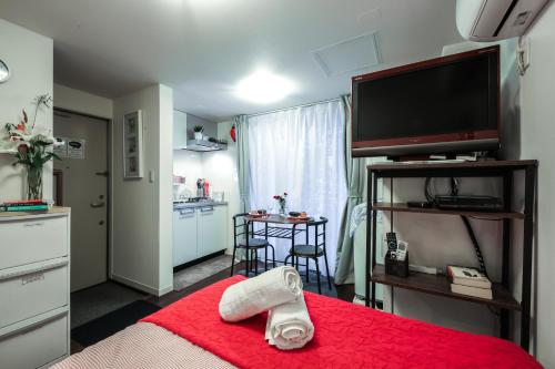 东京Sangubashi Studio Apartment with private entrance的一间设有一张红毯的床和一间厨房的房间