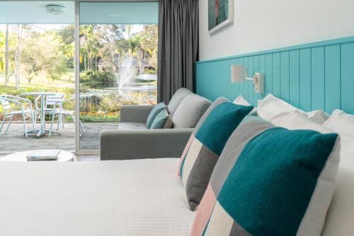 楠巴卡黑兹The Cubana Resort Nambucca Heads的一间卧室设有一张床和一间客厅。