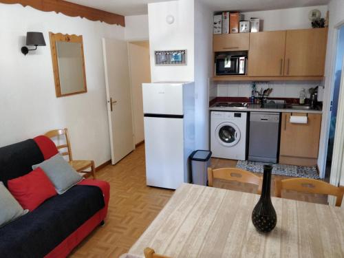 皮伊圣万桑Appartement 4/6 personnes Puy Saint Vincent的厨房以及带沙发和桌子的客厅。