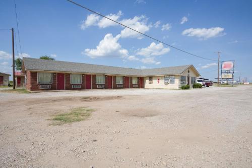 BreckenridgeOYO Hotel Breckenridge TX Hubbard Creek Lake的泥土中的红白建筑