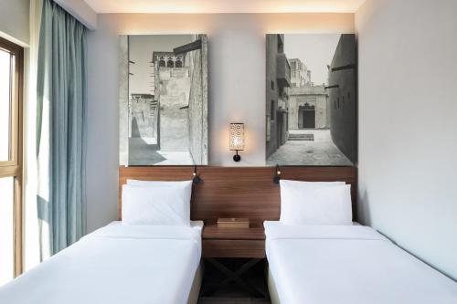 迪拜Super 8 by Wyndham Dubai Deira的带窗户的客房内的两张床
