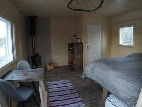 伊纳利Aurora Husky Hut的卧室配有床、桌子和窗户。