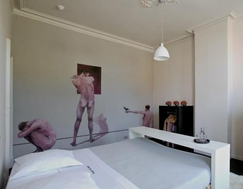 布鲁日布鲁日之夜住宿加早餐旅馆的卧室配有粉红色舞者,墙上绘有彩绘