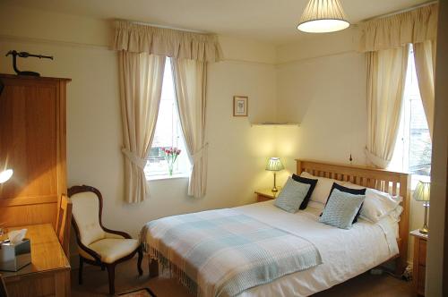 卡伦普顿新域巴顿酒店的卧室配有床、椅子和窗户。