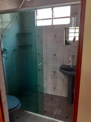 戈亚斯州上帕莱索Casa azul的一间带玻璃淋浴和水槽的浴室