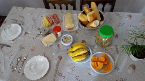 安格拉杜斯雷斯Hospedaria Casa de Maria的餐桌上放有盘子和碗的食物