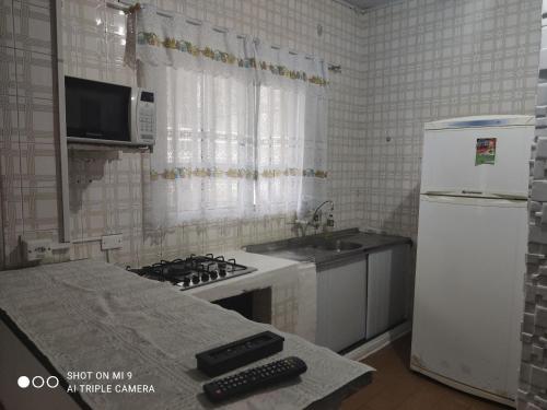 蒙加瓜Recanto的厨房配有炉灶和白色冰箱。