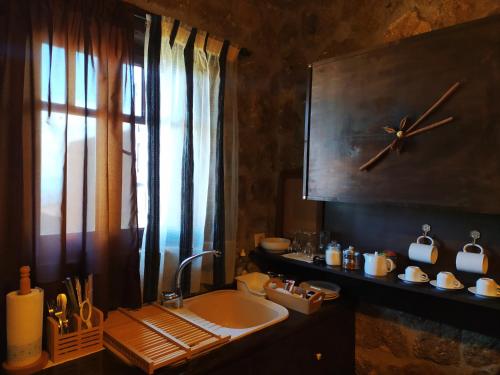 塞尼梅西奇卡罗Ξενώνας Λίκνο的一间带水槽和墙上时钟的浴室
