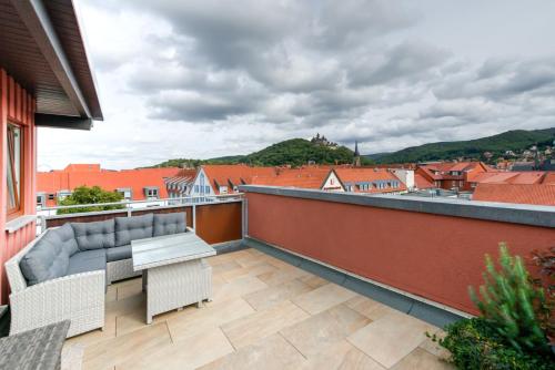 韦尼格罗德Heidequartier Harz的阳台配有沙发和桌椅。