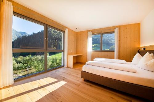 圣莱奥纳尔多因帕西里亚Camping Zögghof的一间卧室设有两张床和大窗户