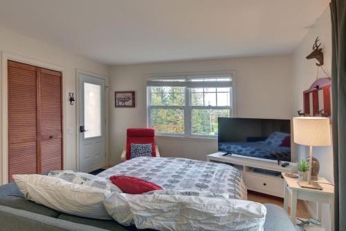 蒙特朗布朗Tranquility Lodge by Instant Suites的一间卧室配有一张床和一台平面电视