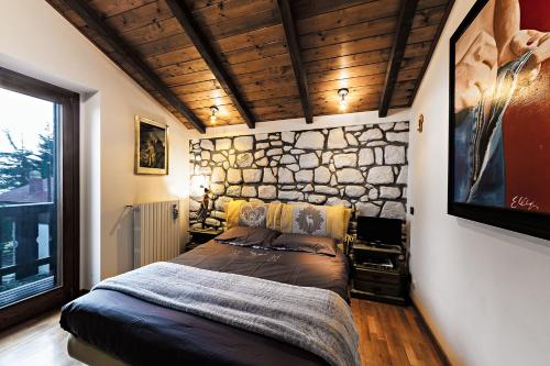 普雷托罗Chalet Mirastelle的一间卧室配有一张石墙床