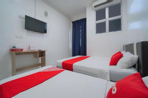 双溪大年OYO 89820 Sp Berlian Inn的酒店客房设有两张床和一台平面电视。
