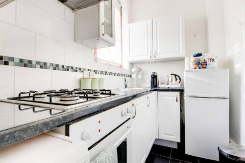 KilnhurstHooton Apartment 1 bed的白色的厨房配有炉灶和冰箱。