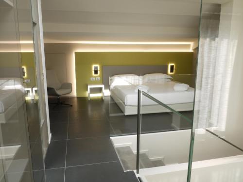 伊莫拉RB del Teatro&Apartaments的酒店客房设有一张床和一个玻璃步入式淋浴间