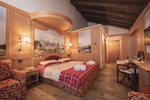 坎皮泰洛迪法萨Hotel Rubino Deluxe的一间卧室配有一张床、一张桌子和一张书桌