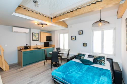 戛纳Duplex : Plage 300m, Clim, Netflix的一间带蓝色床的卧室和一间厨房