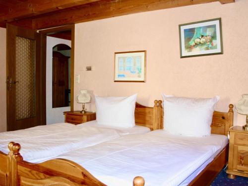 阿尔布斯塔特Hotel Alt Ebingen的一间卧室配有两张带白色床单的床