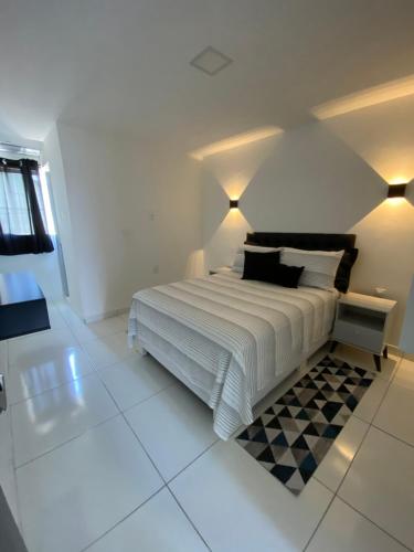 加拉尼温斯Flat Bugayalê的一间白色卧室,配有一张床和 ⁇ 板地板