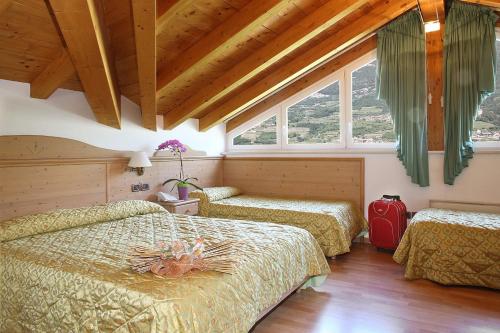 罗韦雷托圣伊拉里奥酒店的一间卧室配有两张床和红色的行李箱