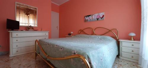 罗马Casa Giustino的一间卧室设有橙色的墙壁、一张床和电视