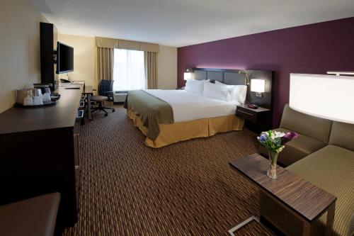 克利尔菲尔德克利尔菲尔德快捷假日酒店及套房的酒店客房设有一张大床和一张沙发。