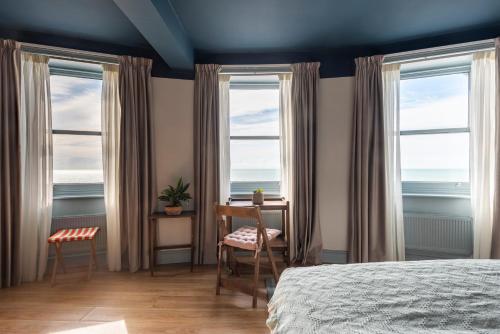 布莱顿霍夫Selina Brighton的一间卧室设有2个窗户、一张桌子和一张床