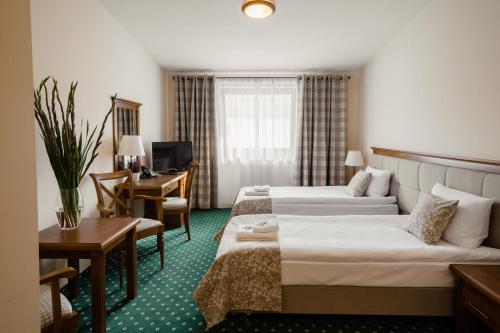 SmyczynaHotel Ranczo Smyczyna的酒店客房配有两张床和一张书桌