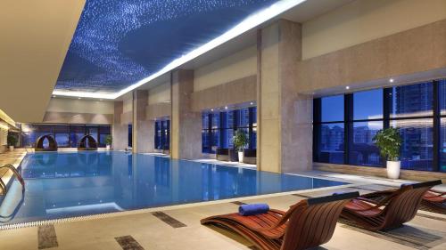 宜宾宜宾鲁能皇冠假日酒店的一座带大型游泳池的建筑中的游泳池