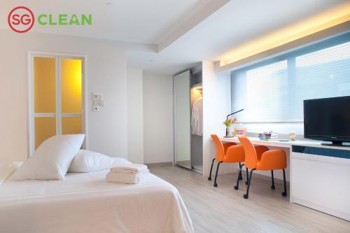 新加坡Wilby Central Serviced Apartments的卧室配有一张床和一张桌子及椅子