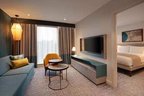 希灵登Staybridge Suites London Heathrow - Bath Road, an IHG Aparthotel的一间酒店客房,配有一张床和一台电视