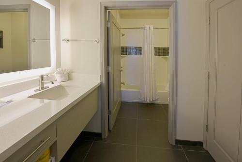 小石城住桥套房酒店 - 小石城 - 医疗中心的白色的浴室设有水槽和淋浴。