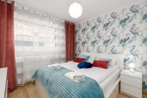 波兹南Sleepway Apartments - Strzelecka 29A-15的一间卧室配有两张带蓝色和红色枕头的床