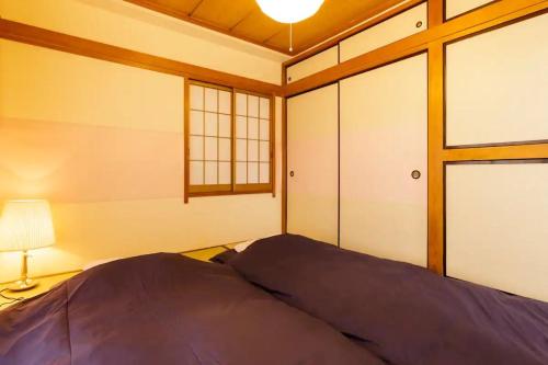 东京NAVI Azabujuban的一间卧室配有床、灯和窗户
