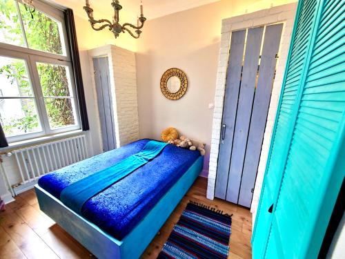 科隆Blue Edition Cologne的一间卧室设有蓝色的床和窗户。