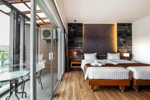 蔻立荣耀黄金酒店的一间卧室设有两张床和玻璃墙