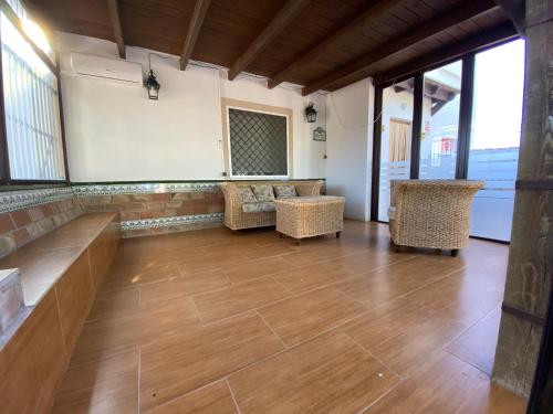 安特克拉Casa Rural el Canal的客房铺有木地板,配有椅子和窗户。
