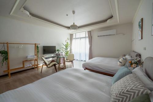 台南千柏旅居的酒店客房配有两张床和一张书桌