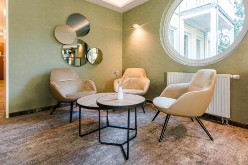 巴贝萨诺别墅家庭式酒店的一个带两把椅子、一张桌子和镜子的沙龙