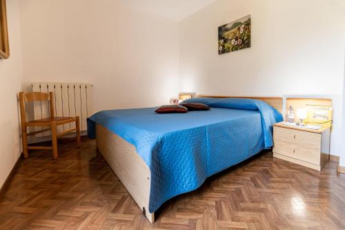 拉比Residence Bonetti的一间卧室设有蓝色的床,铺有木地板。