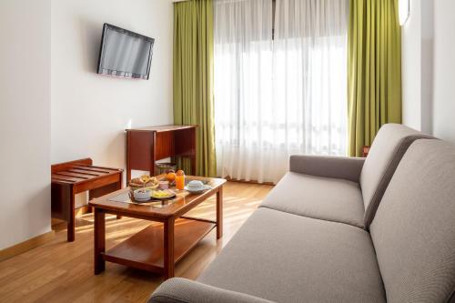 里斯本安霍斯酒店的客厅配有沙发和桌子