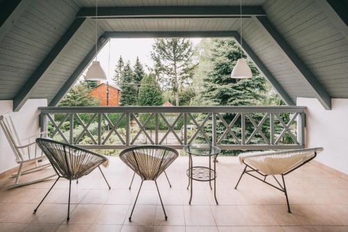 BadacsonyörsCsónakos ház / The boat house的阳台的天井配有三把椅子和一张桌子