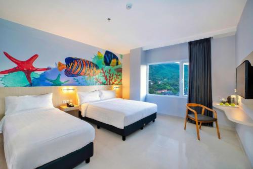 Bitungfavehotel Bitung的酒店客房设有两张床,墙上挂有绘画作品