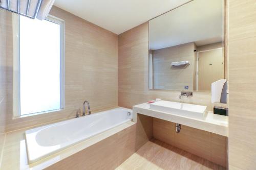 Bitungfavehotel Bitung的带浴缸、水槽和镜子的浴室