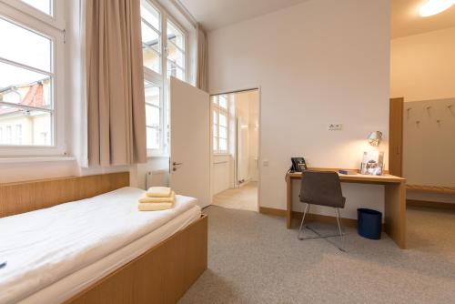 霍夫盖斯马尔霍夫盖斯玛尔酒店的一间卧室配有一张床、一张桌子和一把椅子