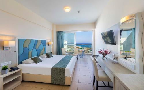 阿依纳帕Tofinis Hotel的酒店客房设有一张床和一张书桌,享有美景。