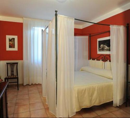 贝瓦尼亚兰奇奥酒店的卧室配有带白色窗帘的天蓬床
