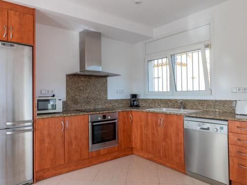 艾姆布里亚布拉瓦Holiday Home Requesens by Interhome的厨房配有木制橱柜和不锈钢用具